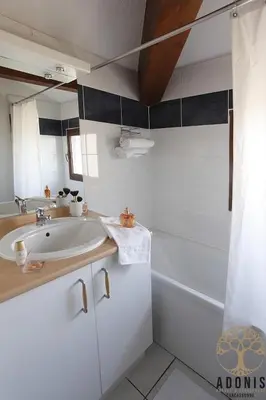 a white bathroom with a sink and a tub at Adonis Carcassonne in Carcassonne