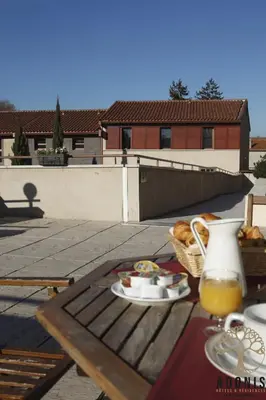 a picnic table with a plate of food and a drink at Adonis Carcassonne in Carcassonne