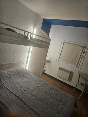 a bedroom with a bunk bed and a window at Hotel Class'Eco Carcassonne in Carcassonne
