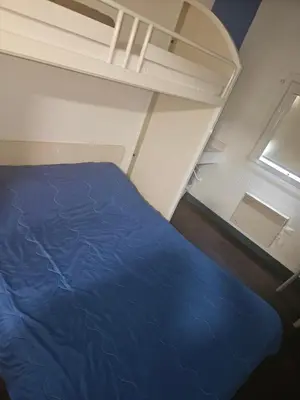 a bedroom with a blue bed and a window at Hotel Class'Eco Carcassonne in Carcassonne