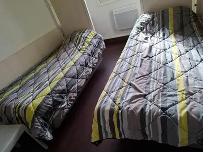 a unmade bed in a room with a bed frame at Hotel Class'Eco Carcassonne in Carcassonne