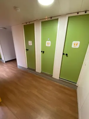 a room with green doors and a wooden floor at Hotel Class'Eco Carcassonne in Carcassonne