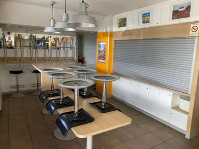 a group of stools in a kitchen with a bar at Hotel Class'Eco Carcassonne in Carcassonne