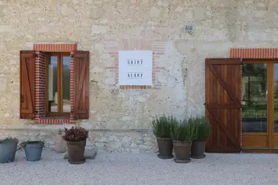 a building with doors and potted plants on it at Maison d'hôtes Saint Alary in Lavaur