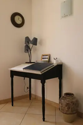 a desk in a room with a clock on the wall at Maison d'hôtes Saint Alary in Lavaur