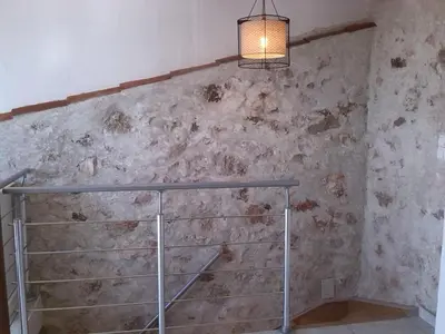 a room with a stone wall with aendant light at Chez Pierre in Bélesta