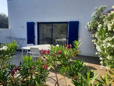 a patio with a table and chairs and flowers at location Silvis dans la propriété Elaia in Tourouzelle