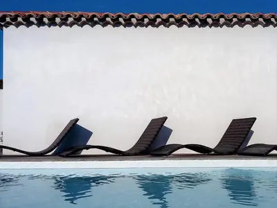 a row of chairs next to a swimming pool at location Silvis dans la propriété Elaia in Tourouzelle