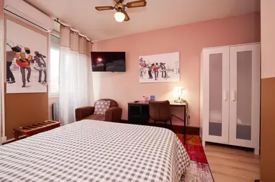a bedroom with a bed and a desk and a tv at hotel de la paix in Pamiers