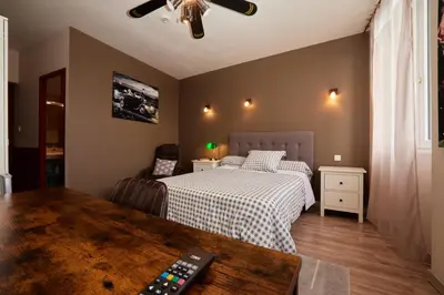 a bedroom with a bed and a remote control at hotel de la paix in Pamiers