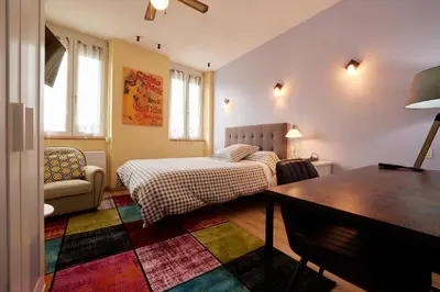a bedroom with a bed and a table in it at hotel de la paix in Pamiers