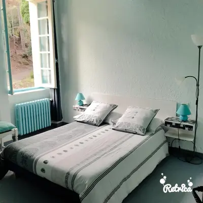a bedroom with a bed with two pillows and a window at Domaine Saint Andrieu in Greffeil