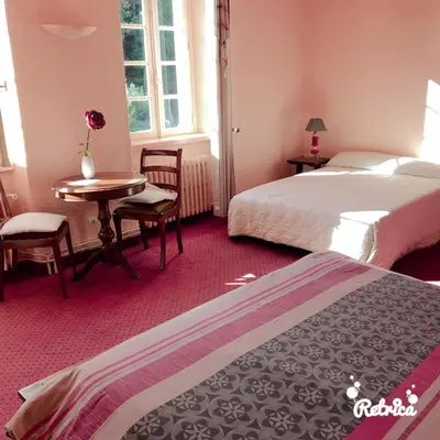 a hotel room with two beds and a table and chairs at Domaine Saint Andrieu in Greffeil