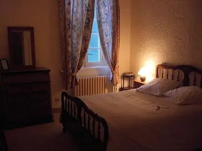 a bedroom with a large bed and a window at Domaine Saint Andrieu in Greffeil