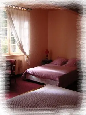 a bedroom with two beds and a window at Domaine Saint Andrieu in Greffeil