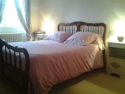 a bedroom with a large bed with pink sheets and pillows at Domaine Saint Andrieu in Greffeil