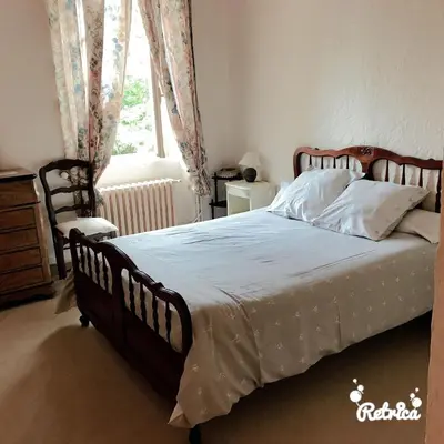 a bedroom with a large bed with white sheets and a window at Domaine Saint Andrieu in Greffeil
