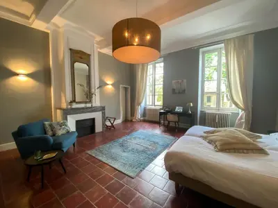 a bedroom with a bed and a chair and a fireplace at Chateau de Blomac in Blomac