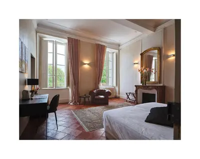 a bedroom with a bed and a desk and a mirror at Chateau de Blomac in Blomac