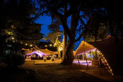 an outdoor wedding with tents and a tree at night at Chateau de Blomac in Blomac