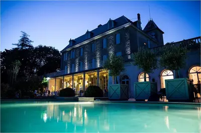 a large building with a swimming pool in front of it at Chateau de Blomac in Blomac