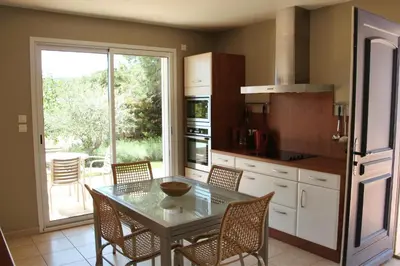 a kitchen with a table and chairs and a window at Lou Daro in Cébazan