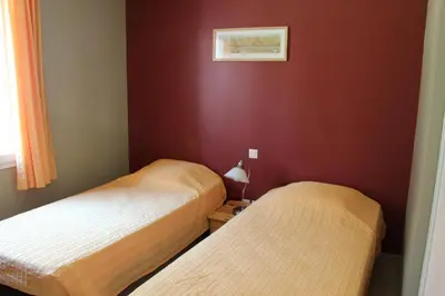 two beds in a room with red walls at Lou Daro in Cébazan