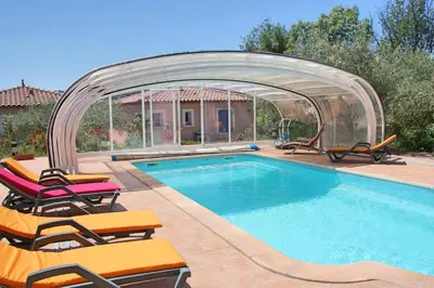 a swimming pool with an arbor and chairs around it at Lou Daro in Cébazan