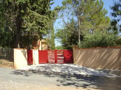 a red gate in front of a fence at Lou Daro in Cébazan