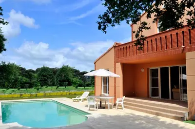 a house with a swimming pool and an umbrella at Lagrange Vacances - Royal Green in Pont-de-Larn