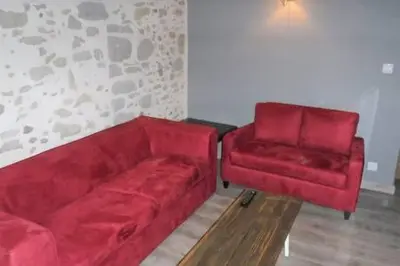 a living room with a red couch and a chair at Le Leon d'or in Mirepoix