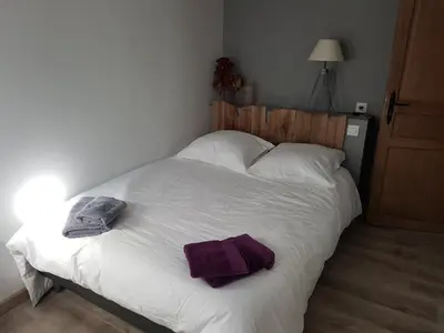 a bedroom with a bed with white sheets and purple towels at Le Leon d'or in Mirepoix