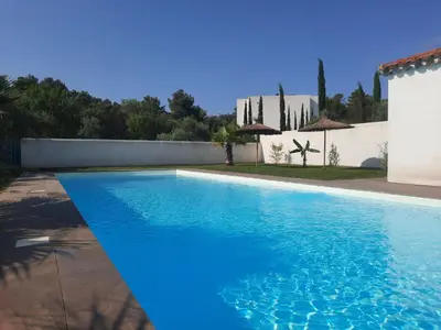 a large blue swimming pool in front of a house at location Phoebé dans la propriété Elaia in Tourouzelle