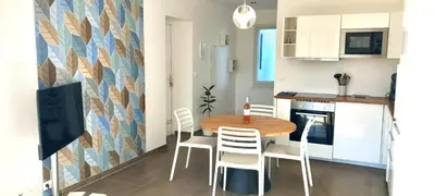 a dining room with a table and chairs in a kitchen at location Phoebé dans la propriété Elaia in Tourouzelle