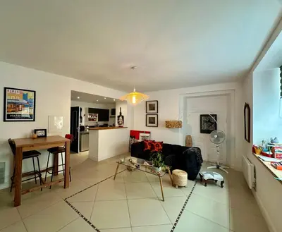 a living room with a table and a kitchen at ART'APPART in Narbonne