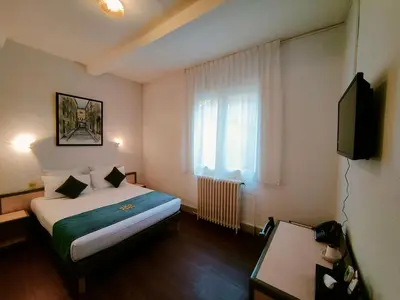 a hotel room with a bed and a window at Will's Hotel in Narbonne