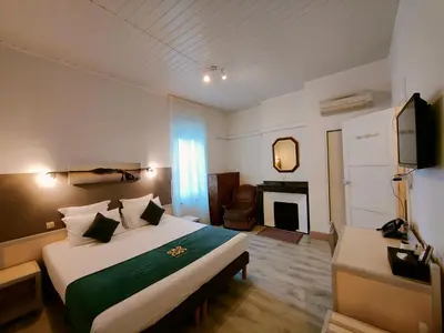 a hotel room with a bed and a fireplace at Will's Hotel in Narbonne