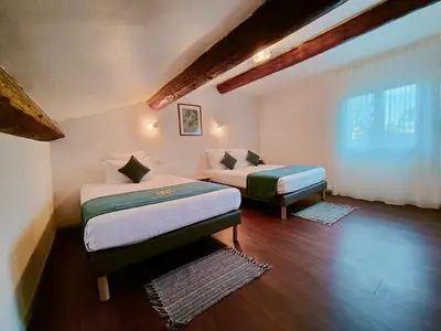 a room with two beds and a window at Will's Hotel in Narbonne