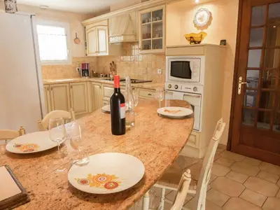 a kitchen with a table with a bottle of wine at Chic Narbonne Pool Retreat in Narbonne