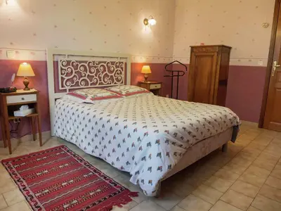 a bedroom with a bed and two tables and two lamps at Chic Narbonne Pool Retreat in Narbonne