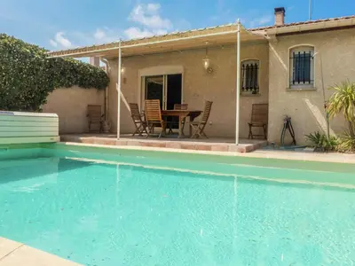 a house with a swimming pool and a table and chairs at Chic Narbonne Pool Retreat in Narbonne