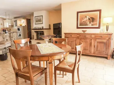 a kitchen and dining room with a wooden table and chairs at Chic Narbonne Pool Retreat in Narbonne