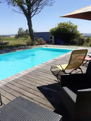 a swimming pool with two chairs and a table at La Bleuette in Montmaur