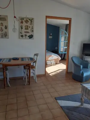 a living room with a table and a bedroom at La Bleuette in Montmaur