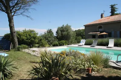 a swimming pool in a yard next to a house at La Bleuette in Montmaur