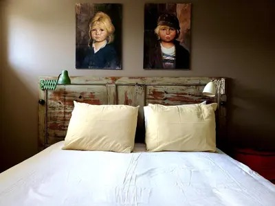 a bedroom with a bed with two paintings on the wall at LOFT - Powered by LIEU - in Villedaigne