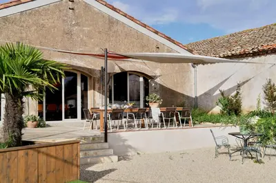 a patio with a table and chairs and an umbrella at LOFT - Powered by LIEU - in Villedaigne