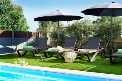 two chairs and an umbrella next to a swimming pool at LOFT - Powered by LIEU - in Villedaigne