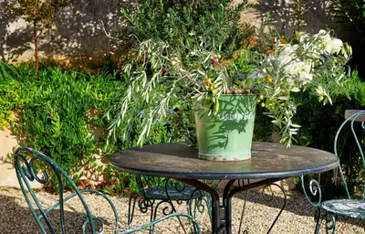 a table with a bucket of flowers on it at LOFT - Powered by LIEU - in Villedaigne