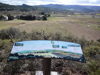 a sign on a hill with a field in the background at Château Villemagne in Lagrasse